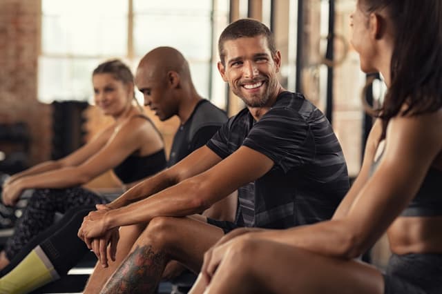 Gym members engaging with mobile-first fitness software on smartphones